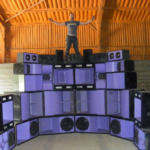 Arron stands on Biosystem sound system.